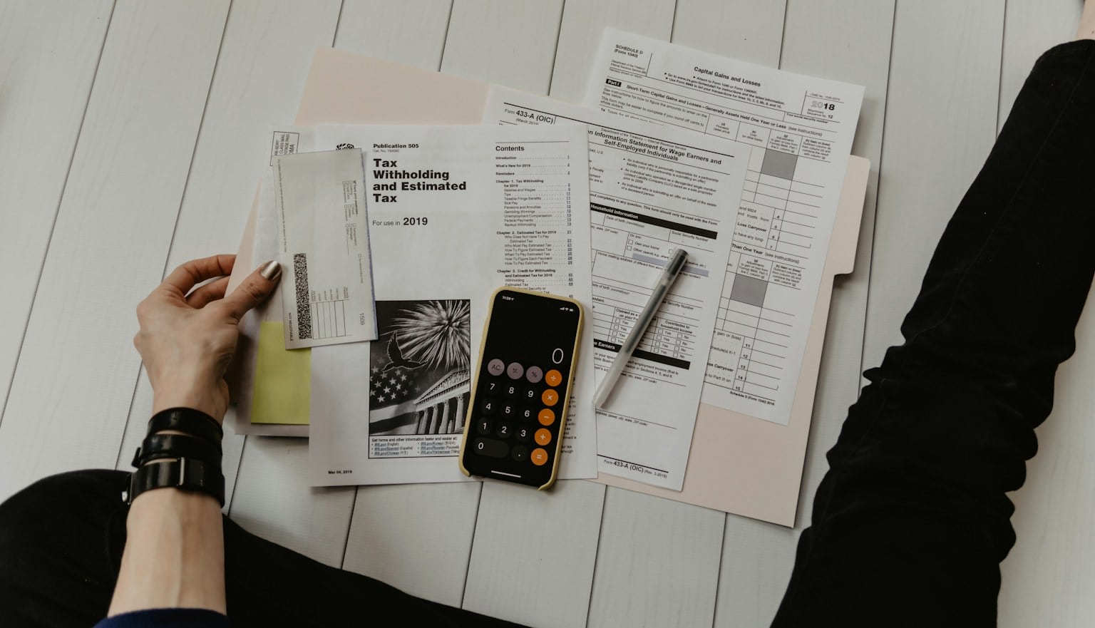 Restaurant financial records, calculator, and coffee arranged on a table